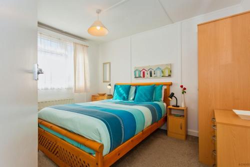 克罗伊德CROYDE SEA BREEZE 3 Bedrooms的一间卧室配有一张带蓝色床单的大床