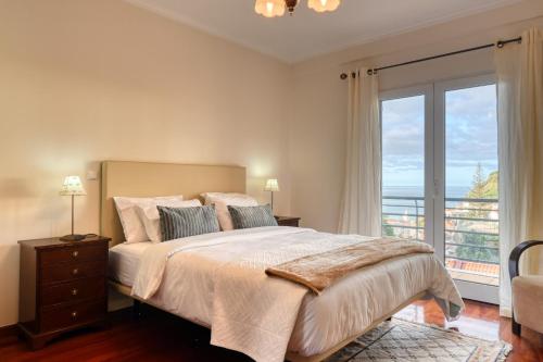 蓬他达维托亚Lidia's Place, a Home in Madeira的一间卧室设有一张大床和一个大窗户