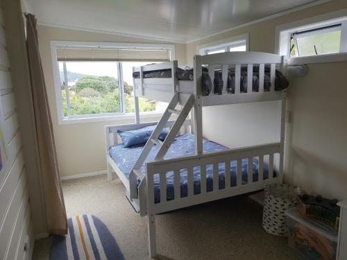 旺阿帕劳阿Stanmore Bay Beachfront Cottage的一间卧室设有两张双层床和一扇窗户。