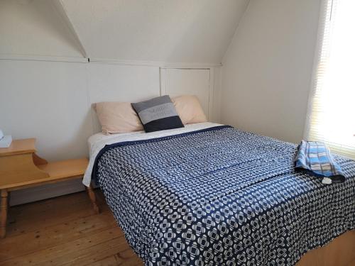 里穆斯基Maison du bord du fleuve à 5 min du centre ville的一间卧室配有一张带蓝色和白色棉被的床