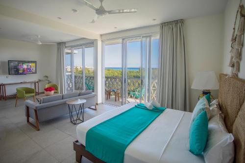 普拉亚卡门Suites Cielo y Mar的一间卧室配有一张床,享有海景