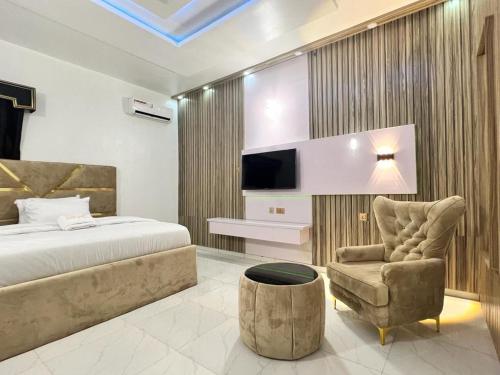 OpeteClique Court Hotel & Suite的一间卧室配有一张床、一张沙发和一把椅子