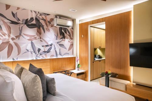 卡塔赫纳Hotel Casona del Porvenir的配有一张床和一台平面电视的酒店客房