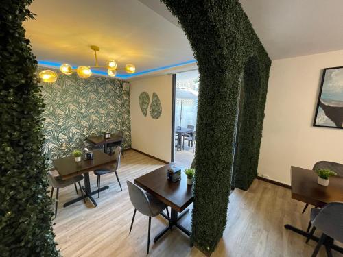 危地马拉Hotel Villas Santander的餐厅拥有常春藤墙壁和桌椅