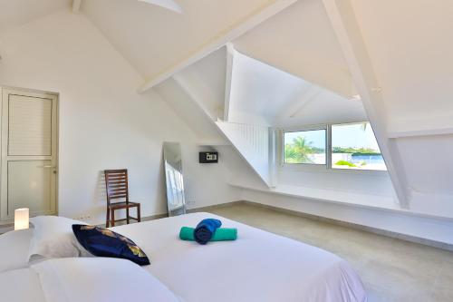 圣马丁岛Modern Beach Villa 1150的白色的卧室设有床和窗户