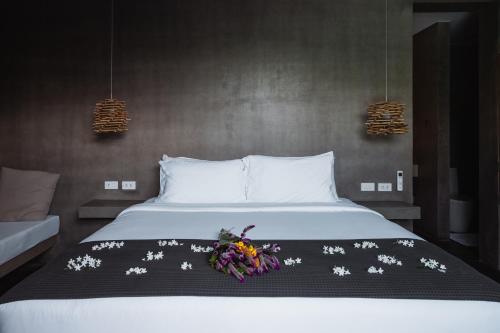 爱妮岛Panorama Villas El Nido的一间卧室,床上放着鲜花
