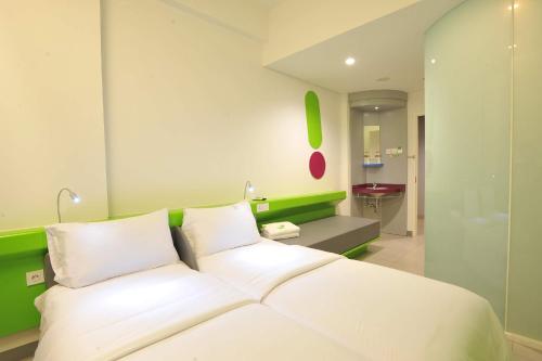 泗水蒂博尼哥罗POP!酒店的卧室配有白色的床和绿色的墙壁