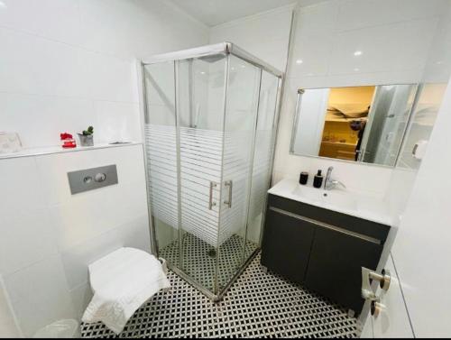 埃拉特BRiGHT AND COZY STUDIO SUiTE EiLAT的一间带玻璃淋浴和水槽的浴室