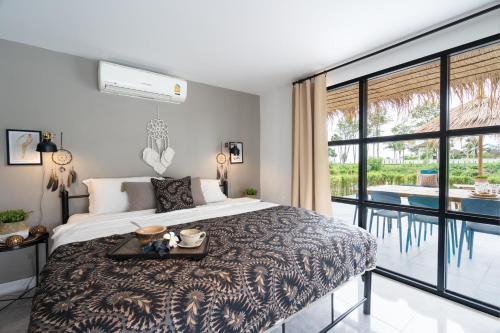 高兰Manao Seaview Pool Villa 20 - 5 Mins Walk To The Beach的一间带大床的卧室和一个阳台