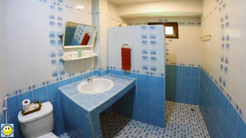 拉威海滩微笑之家酒店及泳池的蓝色和白色的浴室设有水槽和卫生间