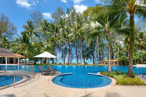 蔻立Outrigger Khao Lak Beach Resort - SHA Extra Plus的棕榈树度假村的游泳池