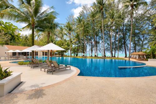 蔻立Outrigger Khao Lak Beach Resort - SHA Extra Plus的棕榈树度假村游泳池的形象