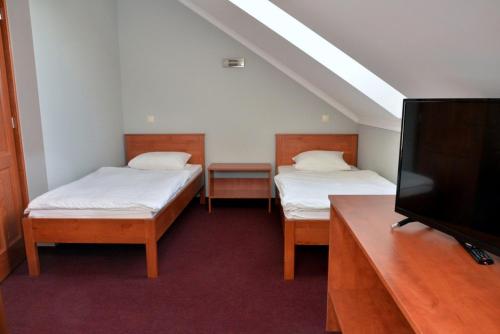 莫尔Belvárosi Vendégház的客房设有两张床和一台平面电视。