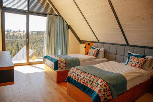 布克维SKOGUR - Home & Resort的带大窗户的客房内的两张床