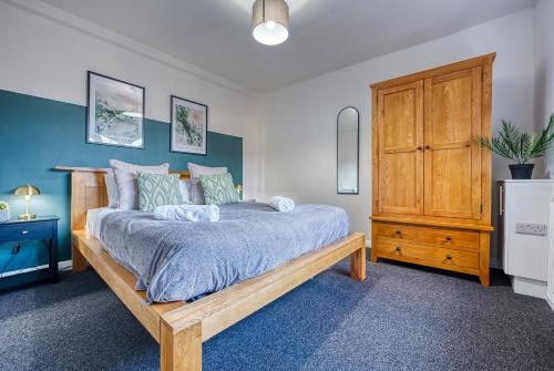 赛伦塞斯特Brewery Loft - 3 Bedroom Bright Spacious apartment in the centre of town, Wifi, Netflix的一间卧室配有一张床和一个木制橱柜
