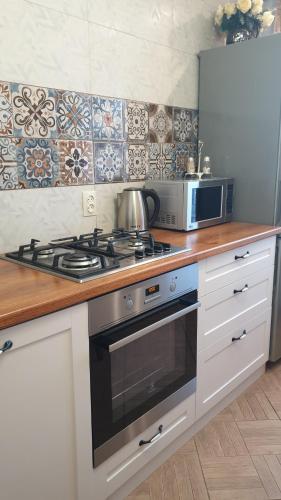 科克舍套1-комнатная квартира的厨房配有炉灶和微波炉。