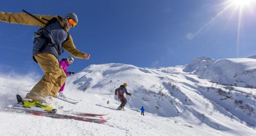 瓦尔莫雷尔Appartement Velaer Valmorel的一群人沿着雪覆盖的山滑雪