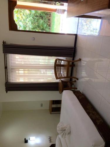 罗威那阿斯塔纳酒店的一间卧室设有窗户和一张带椅子的床