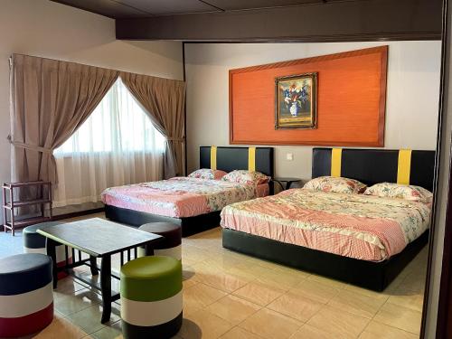 拉瑙SUNRISE RECREATION HOMESTAY & CHALET的酒店客房设有两张床和一张桌子。