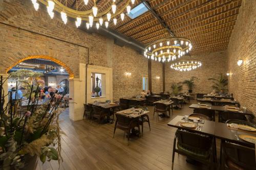 伊斯坦布尔BRAKO HOTEL的餐厅设有桌椅和吊灯。