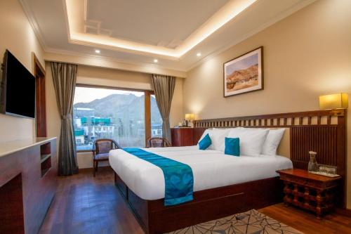 列城Ashoka Ladakh的一间卧室设有一张大床和一个大窗户