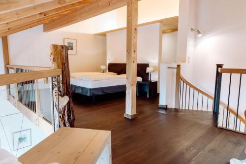 RiederingHirzinger - Gasthaus und Hotel的卧室配有床,楼梯位于房子内