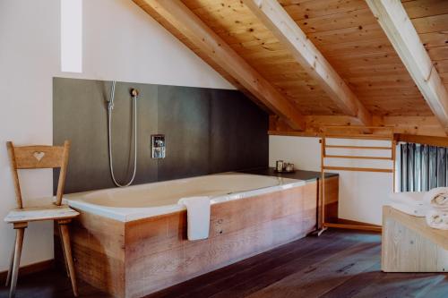 RiederingHirzinger - Gasthaus und Hotel的配有木制天花板的客房内的大浴缸