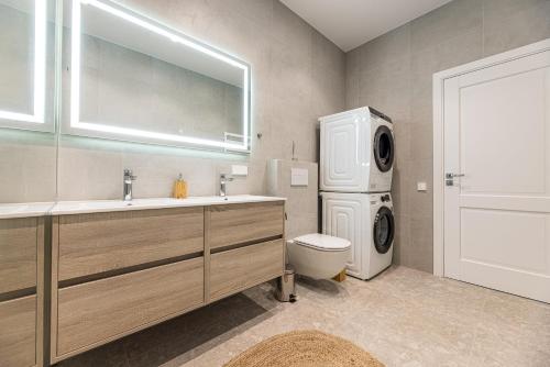Užpelkiai360 Apartments的浴室配有洗衣机、洗衣机和烘干机。