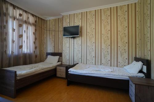 库塔伊西imperator 1 Hotel的配有两张床铺的客房,墙上配有电视