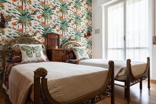 GazzadaGhe Sem Morazzone B&B的一间卧室设有两张床和花卉壁纸