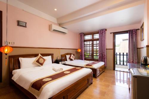 会安Hoa My II Hotel的酒店客房设有两张床和窗户。