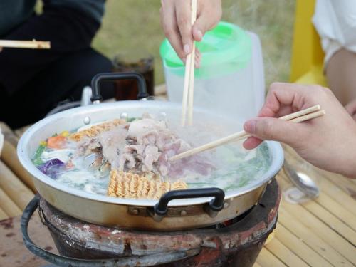 考科Yellowstone Camps O2 Zone Khao Kho的把食物用筷子在锅里做饭的人