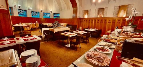 赫拉德茨 - 克拉洛韦区府大酒店的一间设有桌子和盘子的餐厅