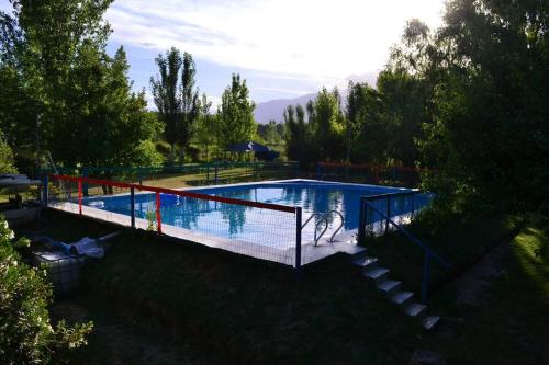 Colonia Las RosasCabaña Ascensión-Caminos del Vino的享有带斜坡和围栏的游泳池的顶部景色