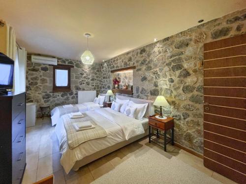 波利兹罗松Ocazzia of Parnassos的一间卧室设有一张大床和石墙