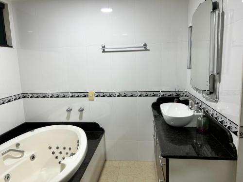 伊瓜苏CASA ACONCHEGO的白色的浴室设有浴缸和水槽。
