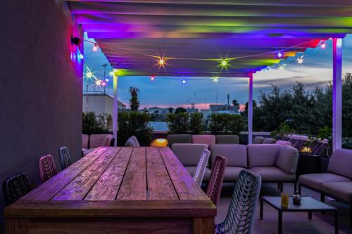 莱切Arryvo Hotel的庭院里的木桌,带紫色灯