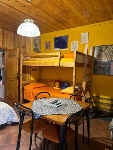 廖卢纳托B&B Il Nido的客房设有两张双层床和一张桌子及椅子。