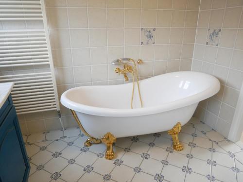卡兰茨奥赫Villa Buiten 108的浴室铺有瓷砖地板,配有白色浴缸。