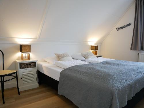 卡兰茨奥赫Villa Buiten 108的一间卧室配有一张床,床头柜配有两盏灯