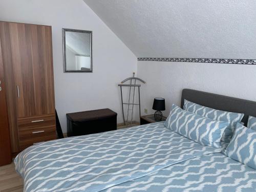 Bechenheim亚当公寓酒店的一间卧室配有一张带蓝色床单和镜子的床