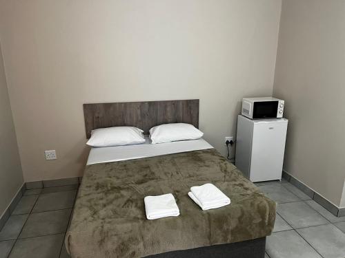 约翰内斯堡Ecomotel Louis Botha的一间卧室配有一张床,上面有两条毛巾