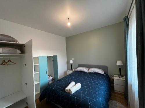 帕艾维坡斯特Appartement T2 Paray vieille poste的一间卧室配有蓝色的床和毛巾