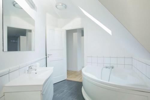 哥本哈根Cozy 3BR Lake View Flat w Bath Tub in Copenhagen的白色的浴室设有浴缸和水槽。