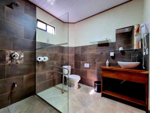 蒙泰韦尔德哥斯达黎加Calathea Lodge Monteverde的一间带水槽、卫生间和玻璃淋浴间的浴室
