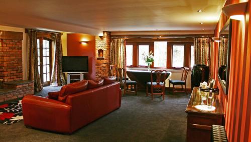 克利夫罗吉本桥酒店的客厅配有红色的沙发和桌子