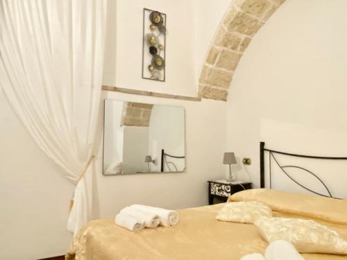 加拉托内Corte Merlata Apartments的一间卧室配有两张带毛巾和镜子的床