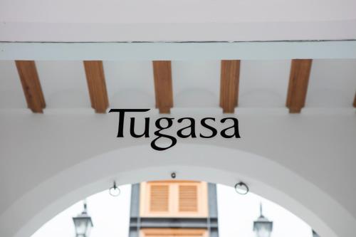 麦地那西多尼亚Hotel Tugasa Casa Palacio Medina Sidonia的窗口上读图卡萨的标志