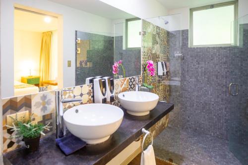 曼努埃尔安东尼奥La Vela Boutique Hotel的一间带水槽和淋浴的浴室