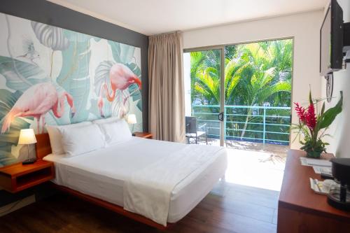 曼努埃尔安东尼奥La Vela Boutique Hotel的一间卧室设有一张床和一个大窗户